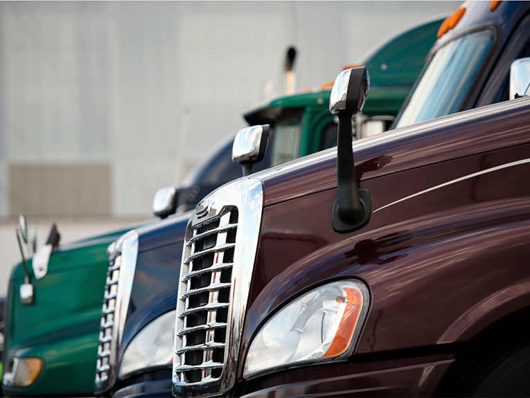 image of three different colored semi trucks parked next to each other