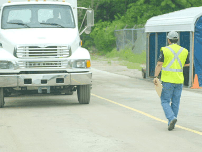 image of white Apex truck, an instructor outside directing student