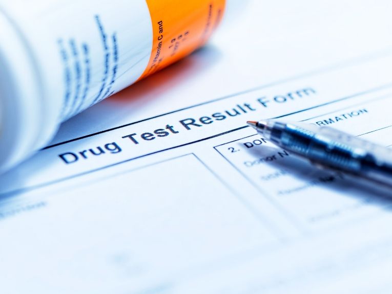 image of drug test result paper, a pen on top