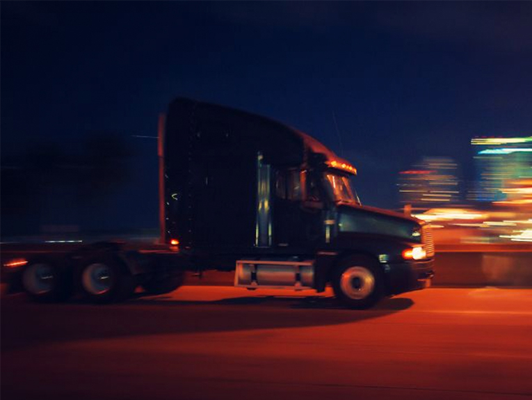image of truck driving at night, blurred to show motion