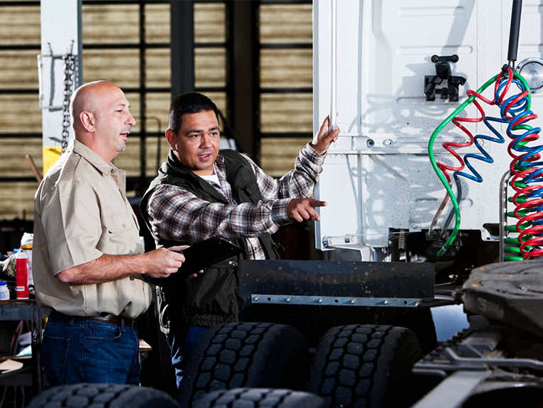 image of two people looking at back of semi truck