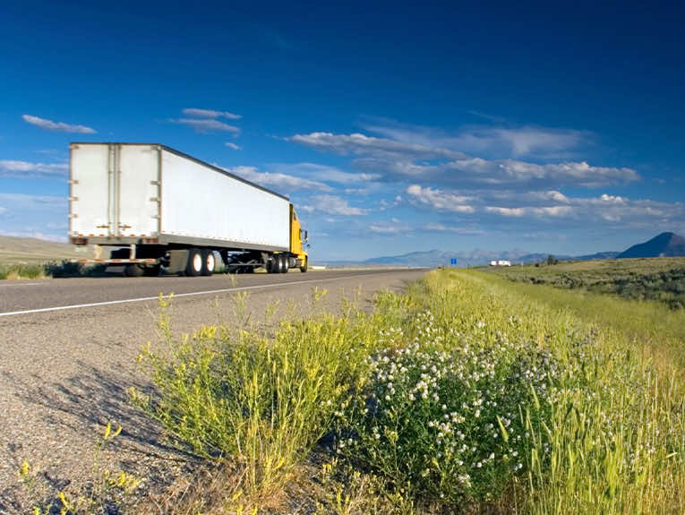 image of yellow and white semi truck driving on road