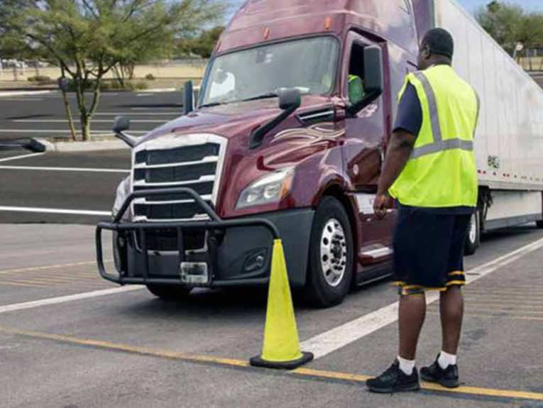 image of burgundy semi with instructor in front