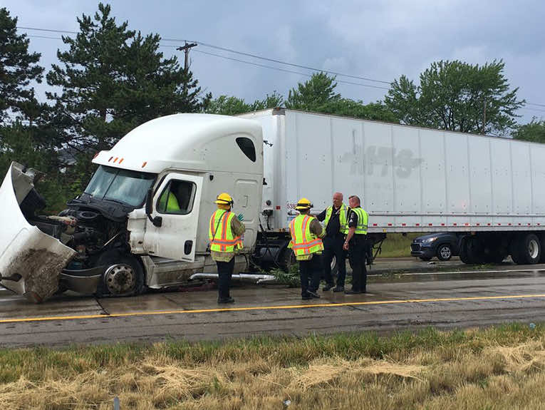 image of crashed white semi truck with workers in front of it