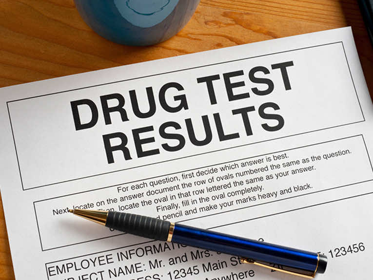 Image of a paper with the words "drug test results" at the top, a pen laying on the paper