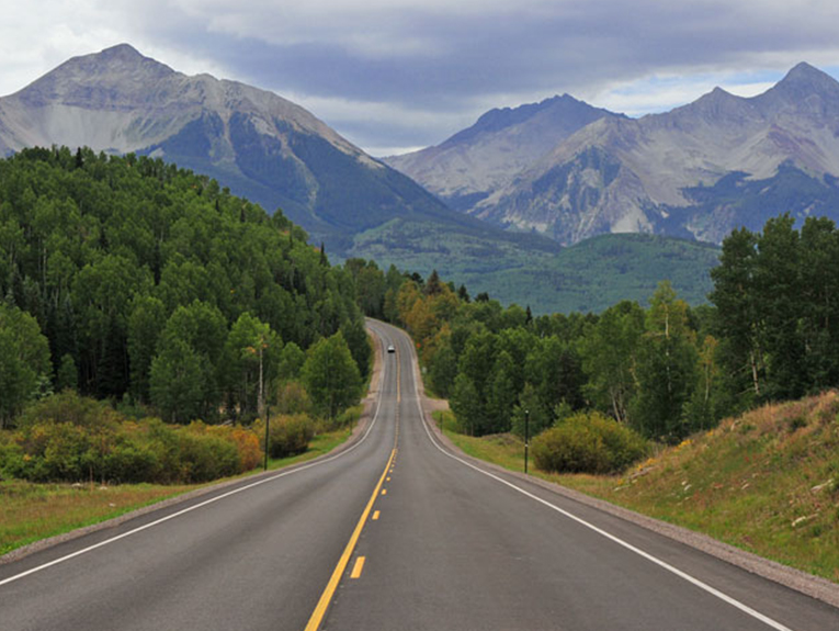 image of highway road through forest and mountains