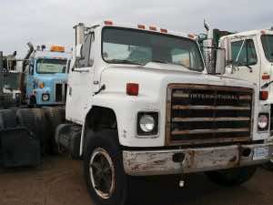 old semi-cabs in a dirt lot