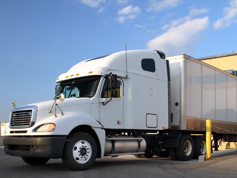 image of white semi truck backed into docking port