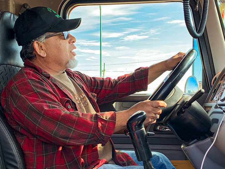 image of older man in red flannel driving truck