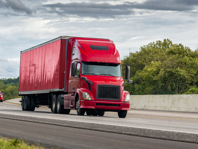 image of red semi truck driving on highway