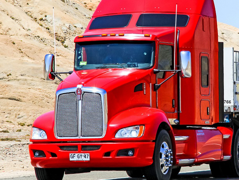 image of red and white semi parked in front of mountain