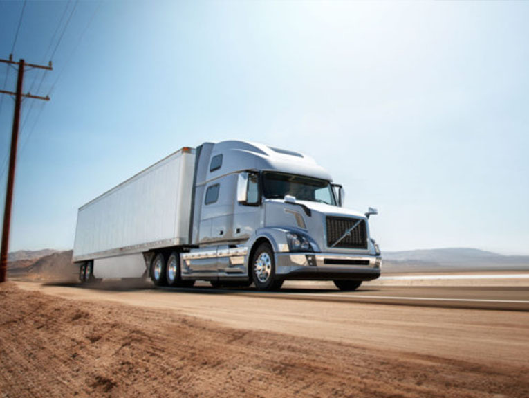 Silver truck driving on desert road