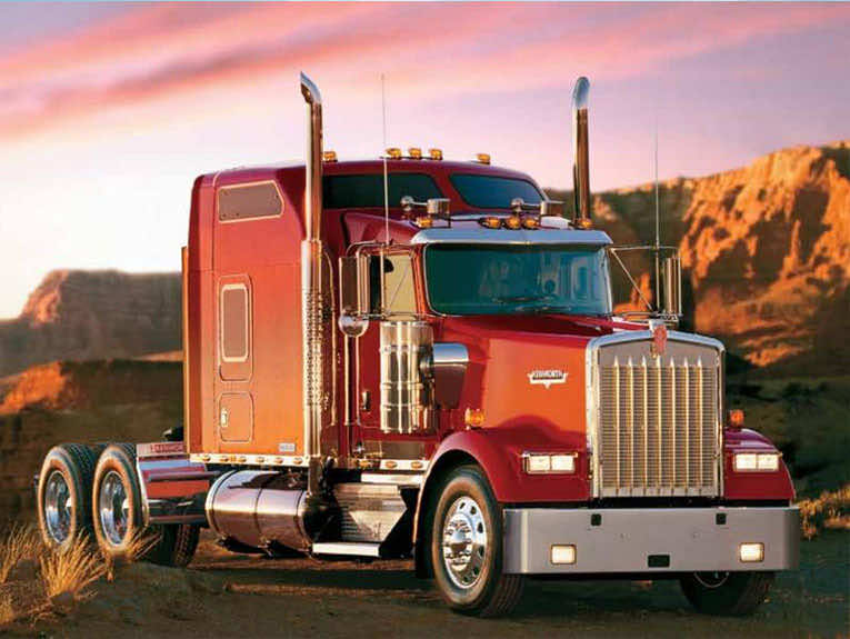 image of red semi cab parked in front of mountains during sunset