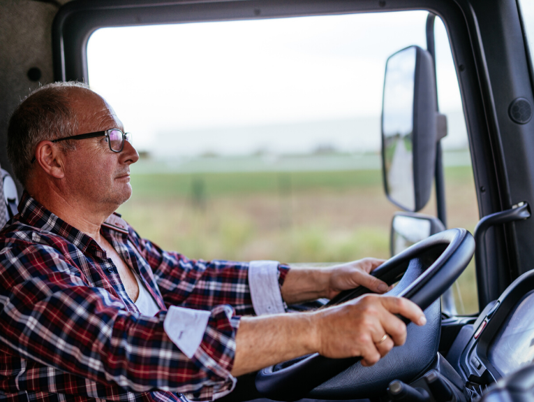 image of older man in red flannel driving truck
