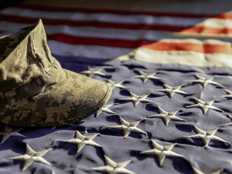 image of American flag with army hat laying on top