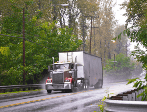 truck driving down rainy road