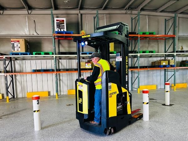 Instructor demonstrating maneuver on warehouse training equipment