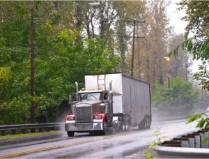 truck driving down rainy road