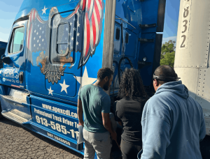Apex semi truck cab, instructors and students standing nearby