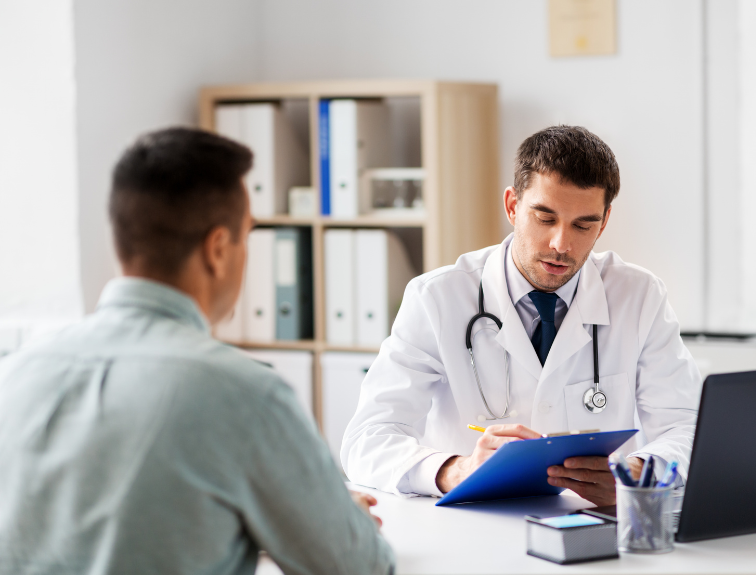 Doctor taking notes on a clipboard, patient sitting in front of him