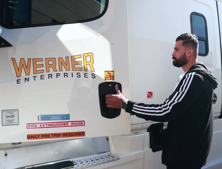 Student driver opening up door of a Werner semi truck